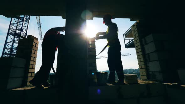 People Work at a Building Site, Laying Bricks.