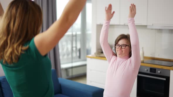 Girl with Down Syndrome and Her Mom Practicing Yoga Position at Home Tree Position