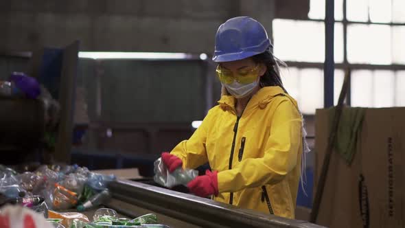 Womanvolunteer in Yellow and Transparent Protecting Glasses and Mask Sorting Used Plastic Bottles at