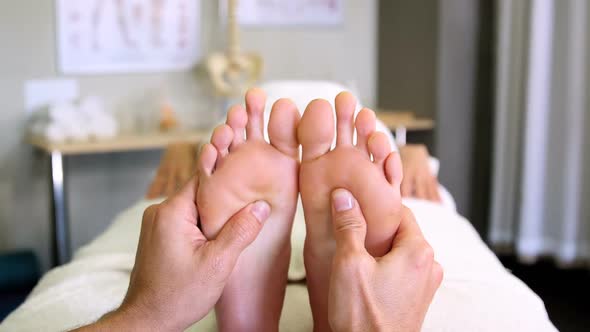 Physiotherapist giving foot massage to a woman