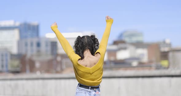 Happy successful woman celebrating with city on background