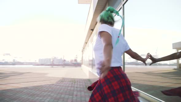 Attractive Young Woman in a Stylish Look and Green Hair Dancing Freely on Urban Background Slow