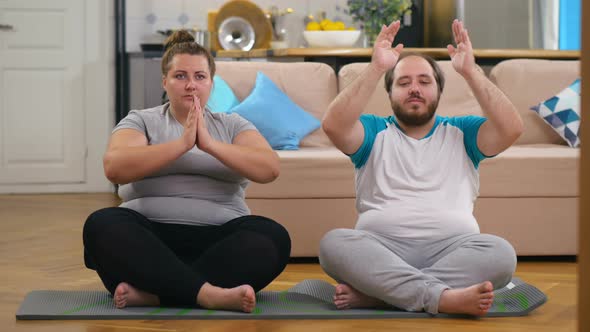 Overweight Couple Doing Exercises at Home Trying To Lose Weight