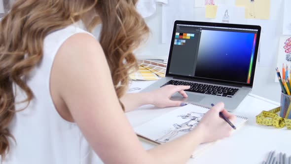 Artist Looks at the Computer and Selects Shades for a New Collection of Clothes