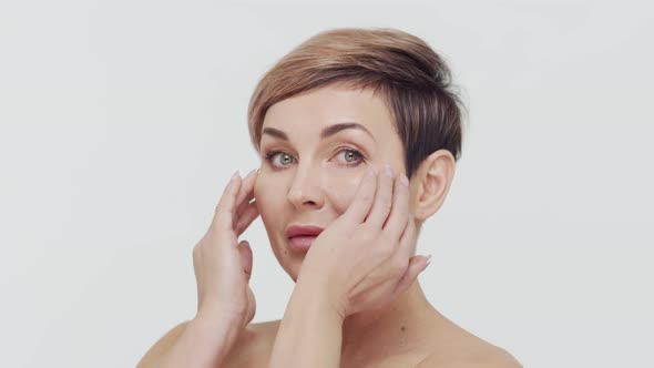 Close-up of middle aged mature woman over white background.