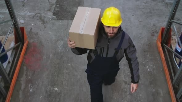 Male Warehouse Worker Carrying Box