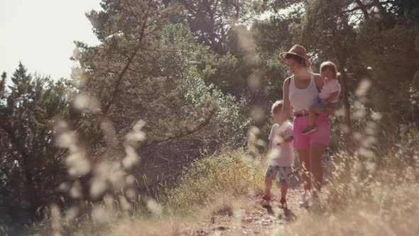 Mom with Children Together on a Walk in the Park