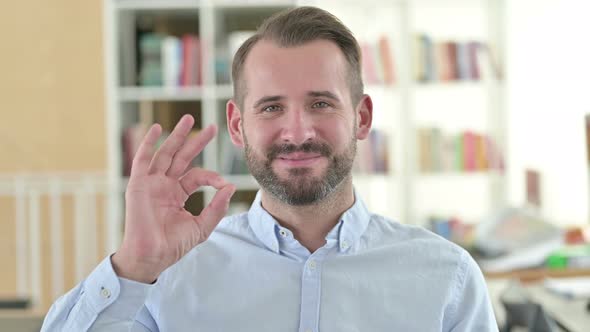 Portrait of Smiling Young Man with Ok Sign 