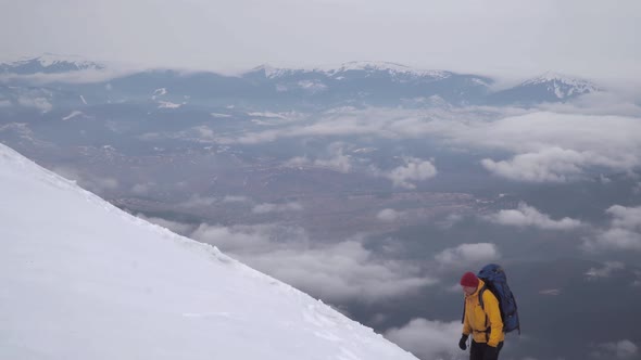 A Traveler Climbs the Snowy Slope of the Mountain