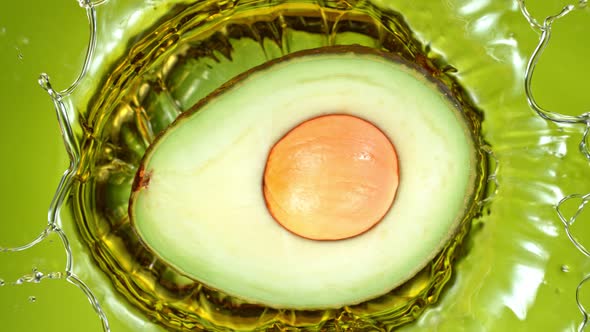 Super Slow Motion Shot of Fresh Avocado Falling and Splashing Into Oil at 1000 Fps