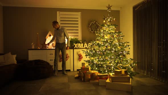 Dad Ringing Bell in Front of Christmas Tree