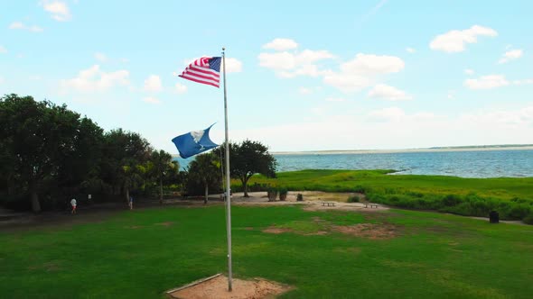 United States and South Carolina flags waving in the wind.