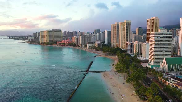 Drone Flyover Hawaiian Beach with Resort Hotel Buildings and Breakwall On Waikiki Beach In Honolulu,