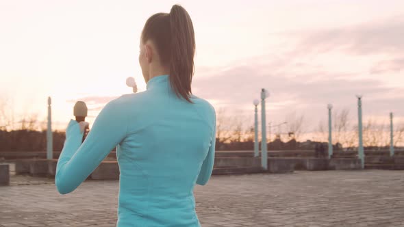 Young, beautiful and sporty woman having evening training outdoor.