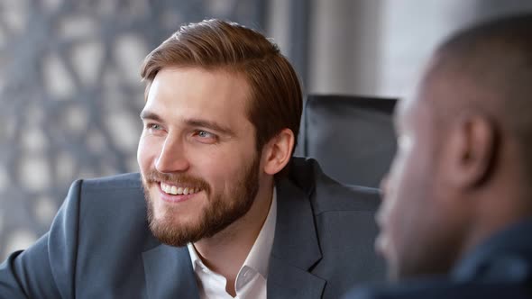 Smiling boss listening to subordinate talking about vacation