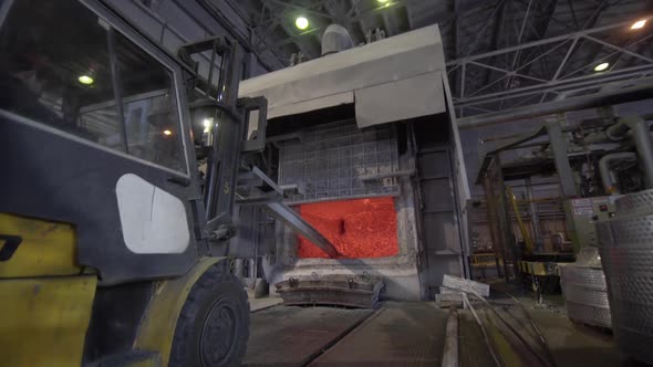 Camera Is Moving Forward To Blast Furnace. Loader Mixes Molten Aluminum in a Blast Furnace