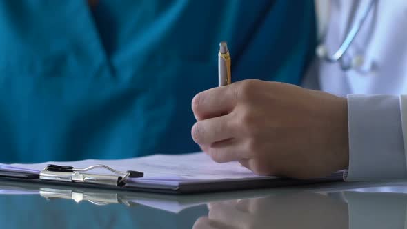 Doctor and Nurse Filling Report Document, Medical Intern Practicing in Hospital