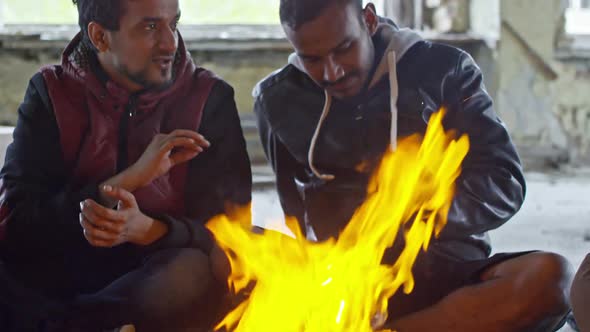 Arab Men Warming by Fire in Abandoned Building