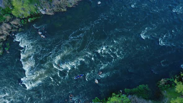 Aerial View of a Kayak Boat Rushing Along with a Stormy Stream Between the Stones at High Speed