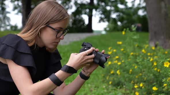 Profile of Young Female Photographer With Camera Taking Photo of Flowers in Park Full Frame Slow Mot