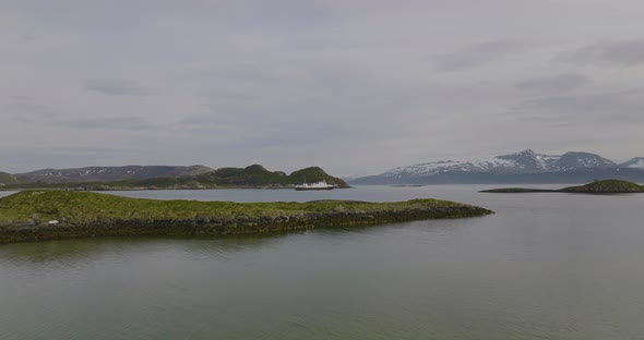 Aerial drone flies towards ferry, beautiful islands, nesting seagulls, northern Norway.