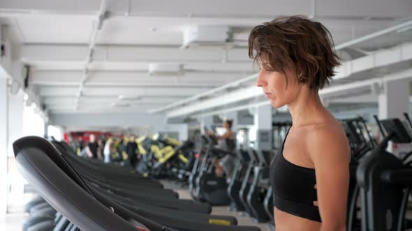 Mature Woman Is Training on Treadmill in Gym. Fitness, Sport Concept.