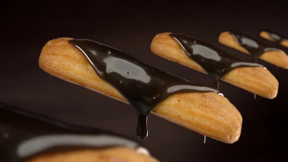 Dark Melted Chocolate Drops From the Fresh Eclairs on Brown Background, Cooking Choux Pastry, Making