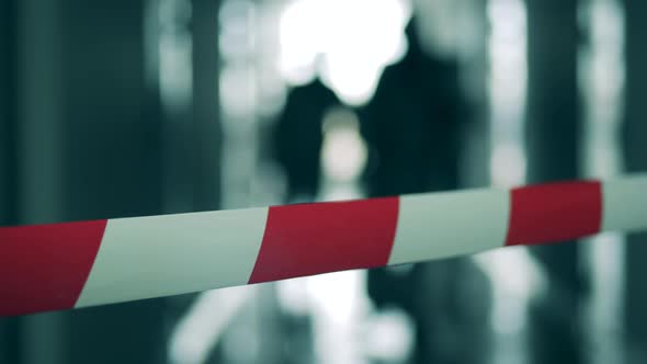 Blurred Image of Sanitary Workers and a Warning Tape in a Close Up. Coronavirus Pandemic, Virus