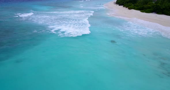 Natural flying clean view of a paradise sunny white sand beach and blue water background in colorful