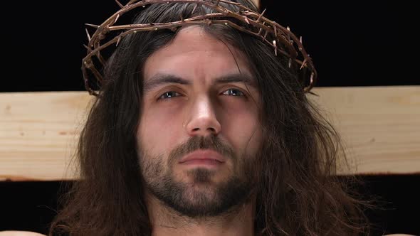 Crying Jesus Christ in Crown of Thorns Looking at Camera Crucifixion on Cross