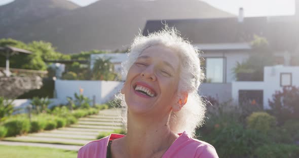 Portrait of happy senior biracial woman in garden on sunny day at retirement home
