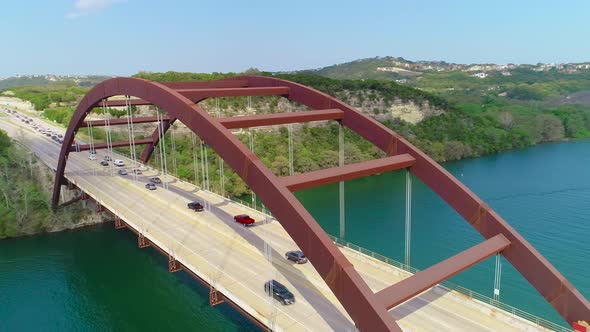 Traffic jam slowly moving across the Pennybacker bridge. Aerial footage is moving counter clock-wise