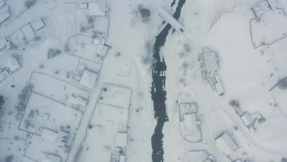 Aerial View of the River with Ice in the Middle of the Village