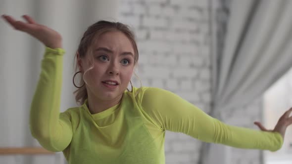 Close Up Portrait of a Young Emotional Girl Dancing Vogue in a Studio Against a Brick Wall