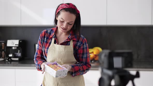 Woman Pastry Chef Demonstrating Present Box with Tasty Macarons to Camera