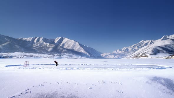 Frozen pond and someone playing hockey.