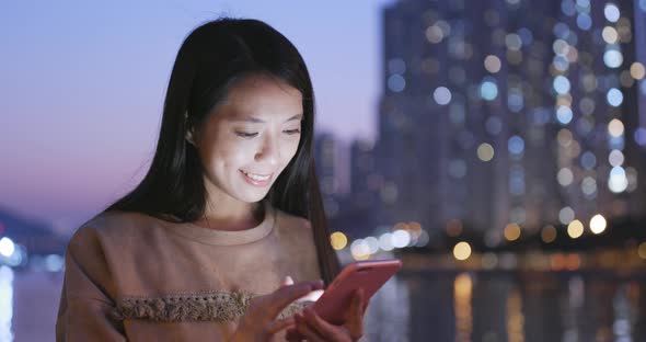 Asian Woman use of smart phone in city at night