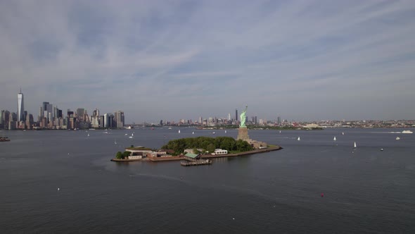 Aerial view around the Statue of Liberty in front of the Brooklyn and Manhattan cityscape in New Yor