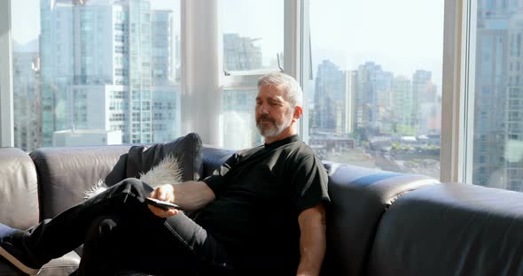 Man using remote on sofa 