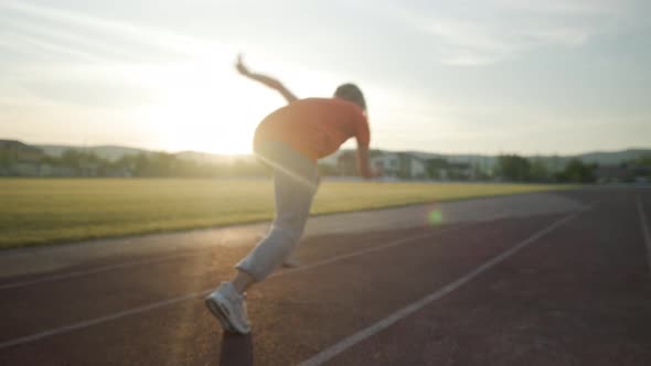 Young Beautiful Girl in Sweatpants and an Orange Tshirt Goes in for Sports