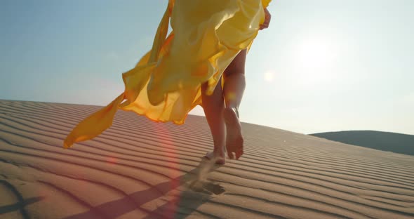 Closeup Woman in Yellow Stylish Fashion Dress Walking Barefoot By Rippled Dune