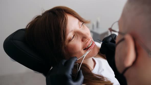 Dentist Orthodontist Adjusting Dental Braces During Orthodontic Treatment of a Young Female Patient