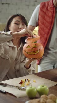 A Young Lady is Looking on Her Handmade Pumpkin