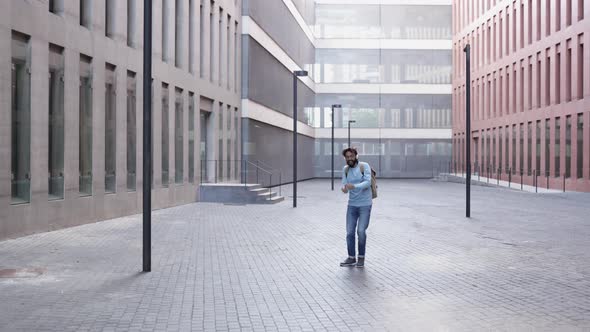 Successful Happy Trendy Young Man Dancing Alone in City Street After Work