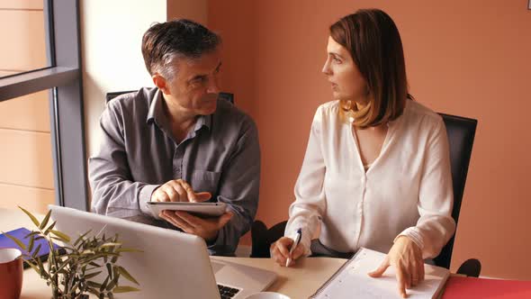 Business people discussing over digital tablet