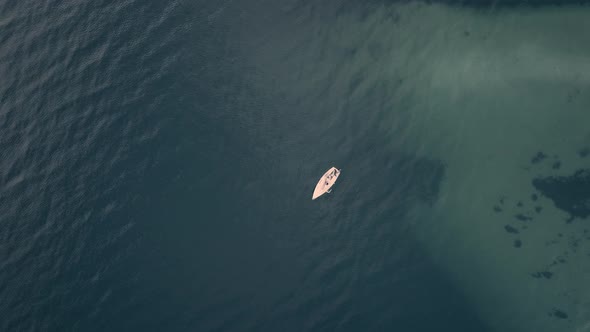 Lonely boat view from above in a blue lake