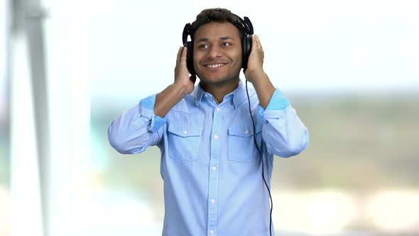 Happy Cheerful Guy Listening To Music in Headphones.