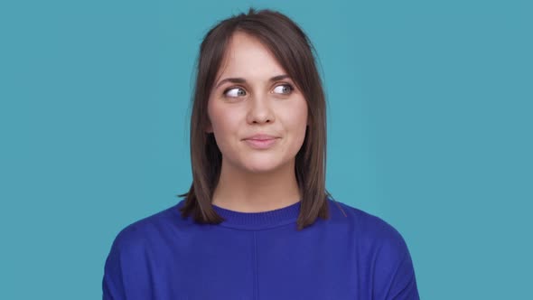 Portrait of Woman with Brown Hair Posing on Camera with Tricky Look Putting Index Finger on Lips