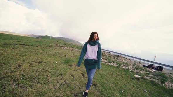 A Young Woman Hiker Running and Spinning on Top of a Mountain