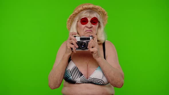Mature Woman Photographer Traveler in Sunglasses Taking Picture Photos on Retro Camera Chroma Key